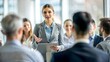 © NHA Studio - 'Businesswoman Giving Educational Speech' – A female presenter addressing a team with a soft focus on the background.
