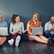 © TamJam/peopleimages.com - Business people, phone and social media in office, floor or happy on break with sharing, email and video. Women, men and tech for contact, excited and reading post by wall with job at creative agency