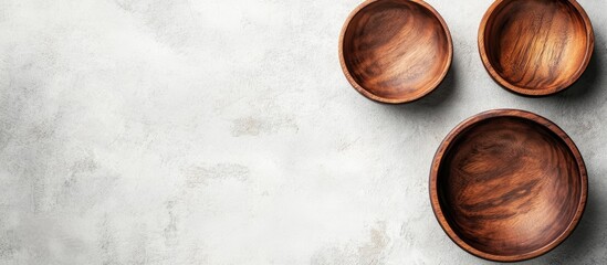 Poster - Empty Wooden Bowl set with copyspace for text or food viewed from above on a white stone table background