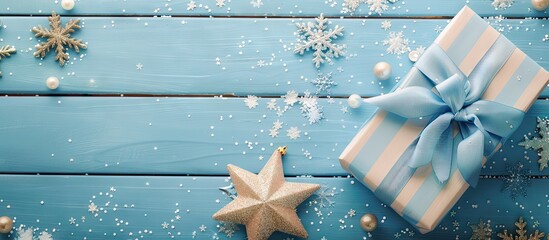 Wall Mural - Flat lay of a gift box adorned with a striped red ribbon and a wooden star on a pastel blue background Concept of Christmas New Year and winter holidays Top view with copyspace