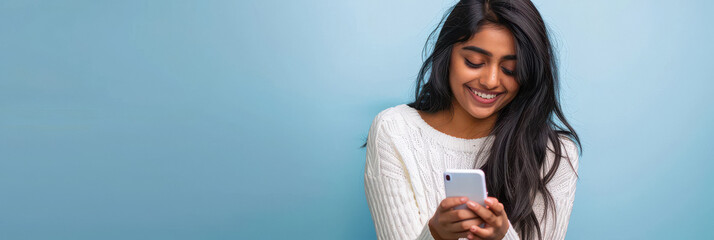 young indian woman using smartphone on blue background