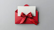 © Hikmet - Blank white gift card with a red ribbon bow or gift voucher inside an open red envelope, isolated on a white or grey background