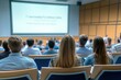 © Anton Gvozdikov - Students sitting in large lecture hall watching presentation screen, focused on academic learning experience, higher education setting