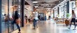 © Aodsy - People moving through a busy open office space with modern industrial design, featuring exposed ceilings, large windows, and collaborative work areas.