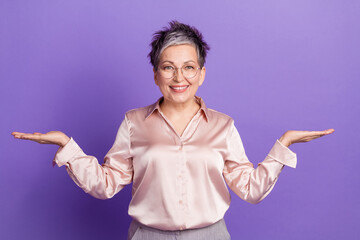 Sticker - Photo portrait of lovely senior lady compare hold empty space dressed stylish satin garment isolated on violet color background