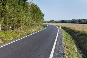 Asphalt road after laying asphalt. Black tarmac rebuilding. Roads in rural areas. 