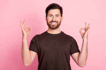 Poster - Photo of satisfied cheerful guy with stubble brunet hair dressed brown t-shirt showing okey nice work isolated on pink color background
