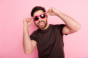 Sticker - Photo of cool positive man with stylish bristle dressed brown t-shirt in sunglass at summer party isolated on pink color background