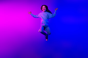 Wall Mural - Full length photo of charming positive small girl wear hoodie jumping high enjoying yoga empty space isolated neon violet color background