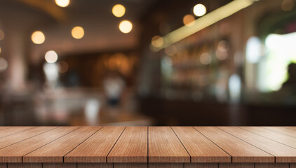 Wall Mural - Empty wooden table top with lights bokeh on blur restaurant background.