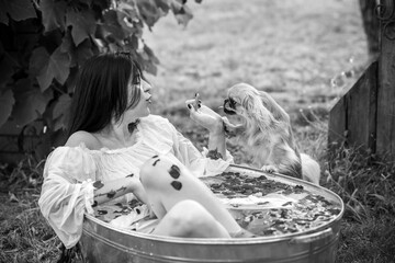 Woman in rustic bath with flowers. Concept of spa, some rite, wicca scene