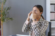 © amnaj - Businesswoman is blowing her nose with a tissue paper while sitting at her desk in the office