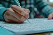 © Parkpoom - A close-up of a student's hand filling in answer sheets during a competitive entrance exam, showing determination and concentration