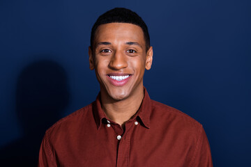 Wall Mural - Portrait of young man beaming smile wear brown shirt isolated on dark blue color background