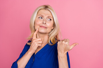 Poster - Photo portrait of attractive retired woman look point skeptical empty space dressed stylish blue clothes isolated on pink color background