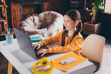 Poster - Photo portrait of nice little girl netbook online lesson sit table wear orange clothes modern interior flat indoors