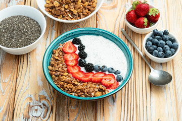 Wall Mural - Healthy breakfast . Yogurt with berries ( strawberry , raspberry , blueberry , blackberry ) , granola and chia seeds . Top view