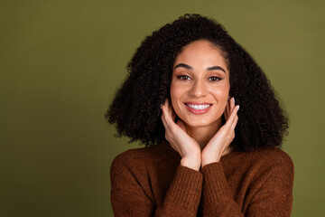 Poster - Portrait of pretty young woman touch face empty space wear sweater isolated on khaki color background