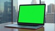 © Ali Hamza Tullah - Laptop Green Screen Mockup, placed on a table. Skyscraper background, Laptop Mockup, Green Screen Laptop