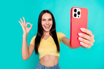 Wall Mural - Photo of pretty young woman phone selfie okey wear top isolated on teal color background