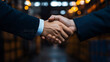 © kwangze - Two businessmen shake hands in a factory setting, symbolizing a successful partnership and collaboration.