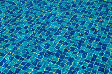 Blue water. Background. Rest in the pool. Pure water. Waves. Blue background.