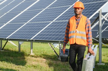 Wall Mural - African American electrician worker installs solar panels. Green energy