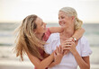 © peopleimages.com - Hug, beach and senior mom with daughter for bonding holiday, love and embrace on weekend travel. Nature, mother and woman laughing on ocean adventure together with smile, fun and island vacation.