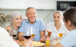 © JackF - Group of joyful seniors at family dinner drinking and chatting at table in kitchen