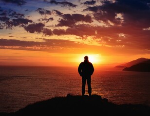 Wall Mural - A lone figure silhouetted against a vibrant sunset, contemplating the horizon.