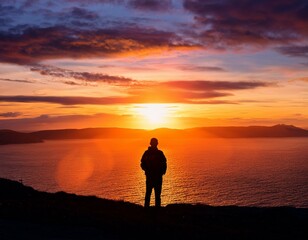 Wall Mural - A lone figure silhouetted against a vibrant sunset, contemplating the horizon.