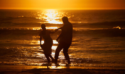 Wall Mural - Love, beach and silhouette of playful couple at sunset for bonding holiday, fun and tropical travel. Nature, man and woman on romantic ocean date together with waves, orange sky and outdoor vacation