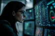 © Elmira - A female IT specialist focuses on assessing digital threats while surrounded by multiple computer screens in a dimly lit office space