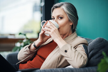 Wall Mural - Coffee, portrait and relax with business woman on sofa in office for break or rest as professional employee. Confident, face and mug with mature person drinking caffeine beverage in workplace