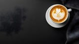 Overhead shot of a cappuccino in a white cup, placed on a black background, wide empty space around, balanced lighting for strong contrast.