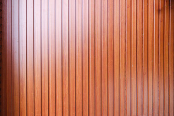Poster - A close-up image of a wooden wall, showcasing its natural texture and warm brown tone. The vertical planks create a repeating unique pattern.