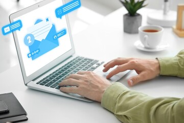 Man using laptop to check e-mail in office