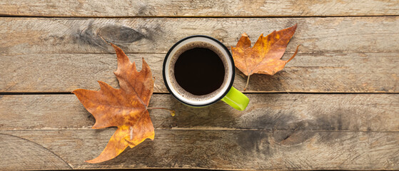 Poster - Cup of aromatic coffee and fallen leaves on wooden background