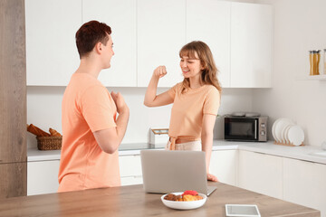 Canvas Print - Young deaf mute couple using sign language in kitchen