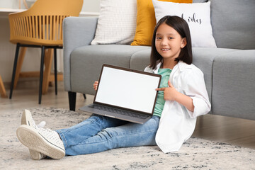 Canvas Print - Little Asian girl with blank laptop at home