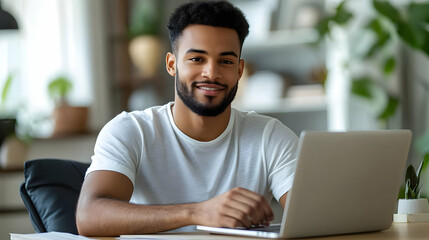 Poster - A smiling man working on a laptop in a cozy environment.