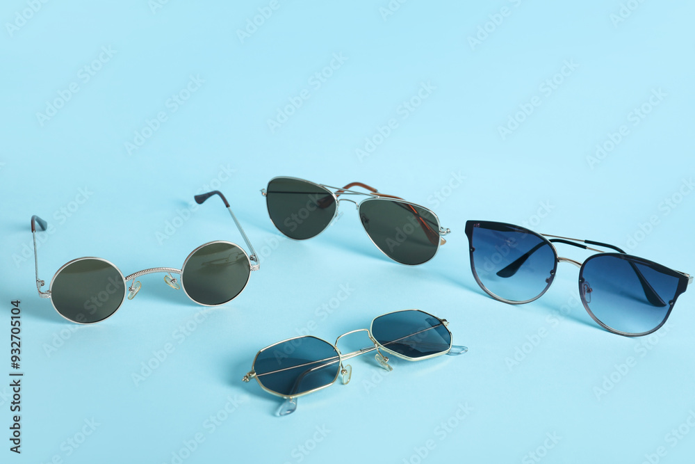 Different stylish sunglasses on blue background
