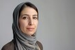 © Larisa - Serene woman in hijab with reflective gaze on grey backdrop