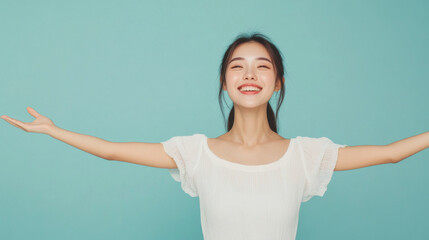 Wall Mural - Young Asian woman with open arms isolated on blue background , studio shot of a beautiful Asian American girl with happy smiling face welcome with open arms on teal color backdrop