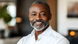 © Siasart Stock - A close-up portrait of a smiling middle-aged black man wearing a white shirt.