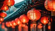 © yiam - Vibrant red Chinese lanterns illuminating the night, creating a festive atmosphere with blurred traditional architecture in background.