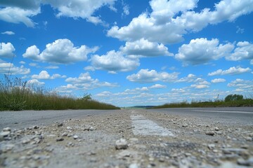 Wall Mural - Road of asphalt under blue sky with clouds