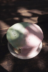 Cake in the form of an underwater sea multicolored world with green and pink colors on a wooden background with sunlight and shadows. Top view.  cake ideas and inspiration, no inscription.