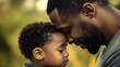 © uros - African American black man, dad father and toddler son boy, standing with foreheads touching. Emotional connection moment. Parent cuddle, kiss, child hug. Family bond, human love, relationship care