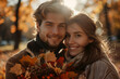© MK studio - A smiling couple stands together in an autumn park, surrounded by golden leaves. The woman holds a bouquet of colorful fall foliage, while both wear cozy sweaters and scarves.